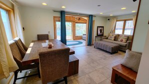 A spacious living area with a wooden dining table, two sofas, and a coffee table.