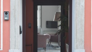 An arched doorway with a number sign, leading to a room with a bed, a television, and a plant. - Villa Bela Vista (Sintra)