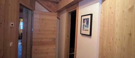 A wooden hallway with a door leading to another room.