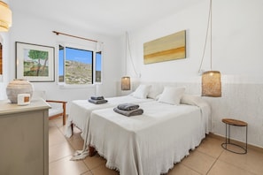 A hotel room with two beds, a large window, a painting, and a small table. - Tramontana 115-P1 - Caressing the Mediterranean (Fornells)