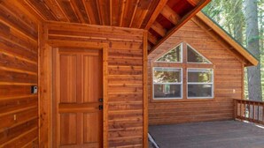 A wooden cabin with a large door and a window with a triangular design. - Everything You Need in a Mountain Cabin (Truckee)
