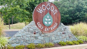 A wooden sign with "The Woods Golf Entrance" and a golf club logo. - GolfView Chalet at the Woods Resort, Central Air and Heat (Hedgesville)