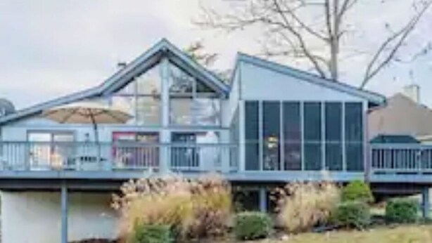 A modern two-story house with a balcony, large windows, and a satellite dish. - GolfView Chalet at the Woods Resort, Central Air and Heat (Hedgesville)
