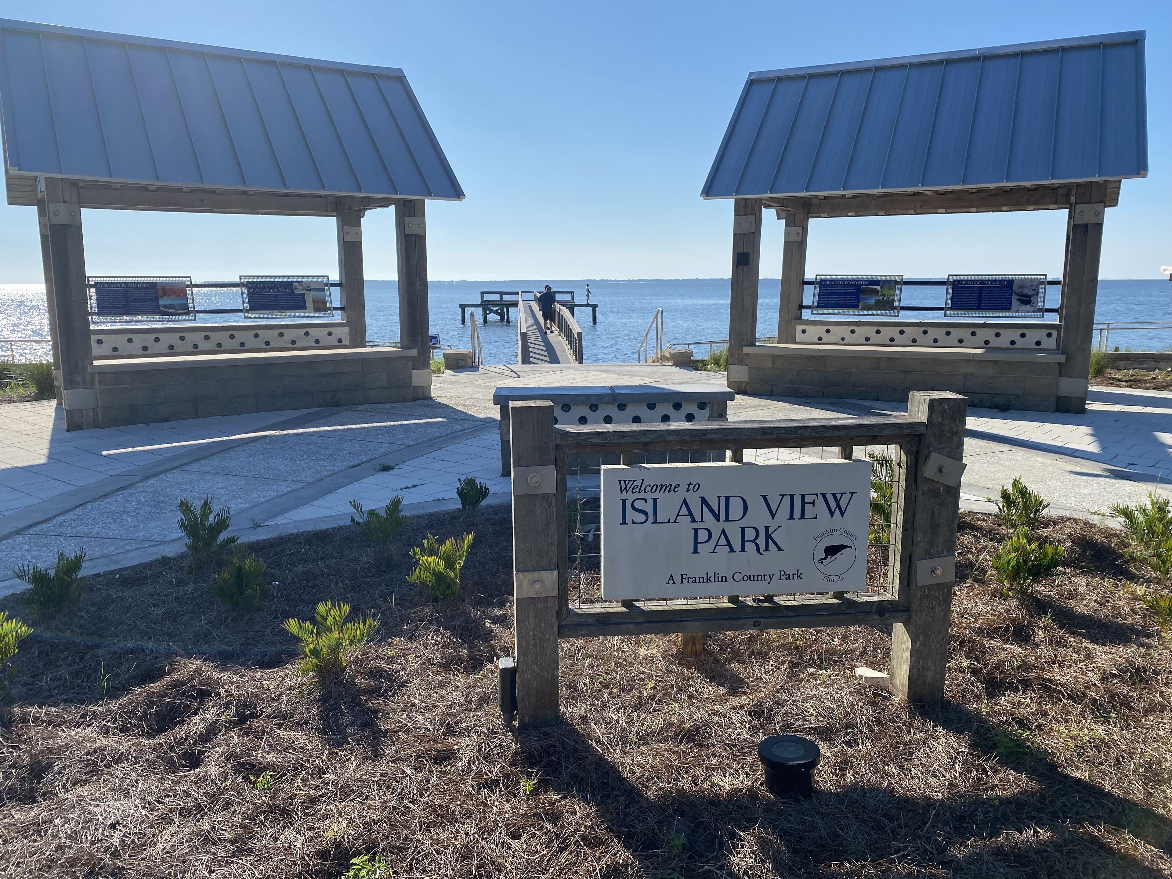 Een bord dat bezoekers verwelkomt in Island View Park, Franklin County, Florida, met uitzicht op het water en een overdekt zitgedeelte.