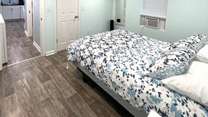 A bedroom with a bed, a dresser, a mirror, and a window with blinds. - The Snapper House-Carrabelle (Carrabelle)