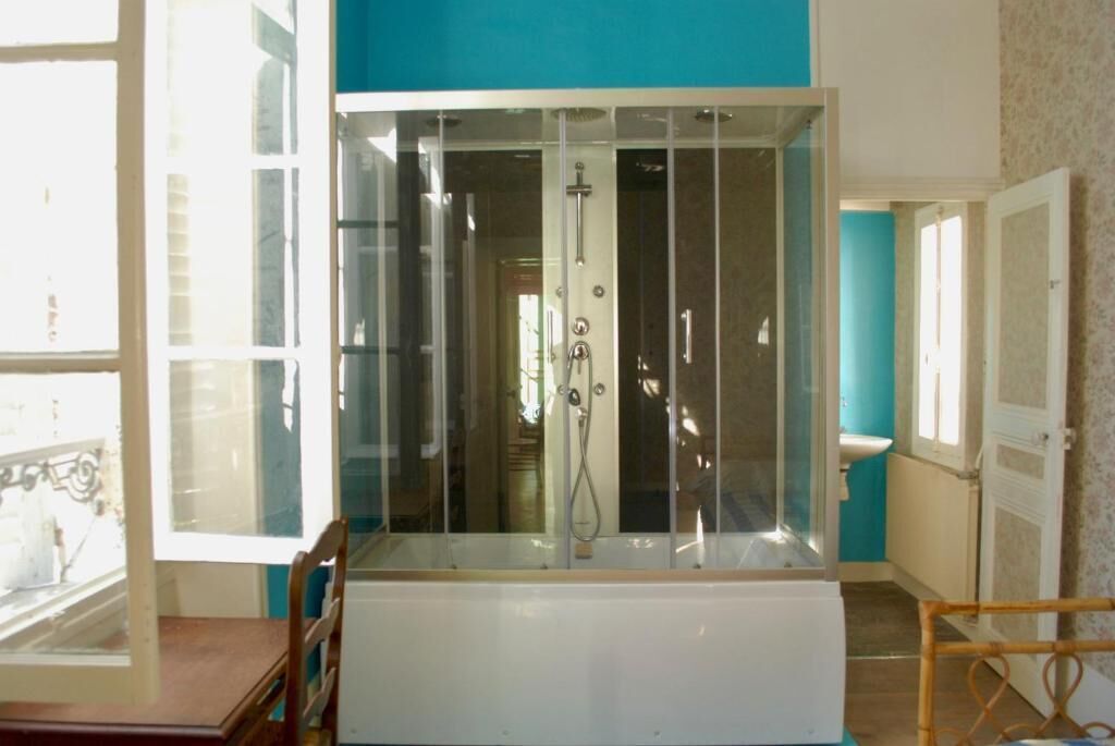 Une salle de bain avec une douche à parois de verre, une baignoire et des toilettes.