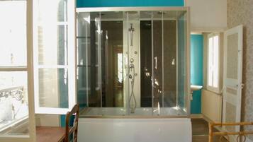 Une salle de bain avec une douche à parois de verre, une baignoire et des toilettes.