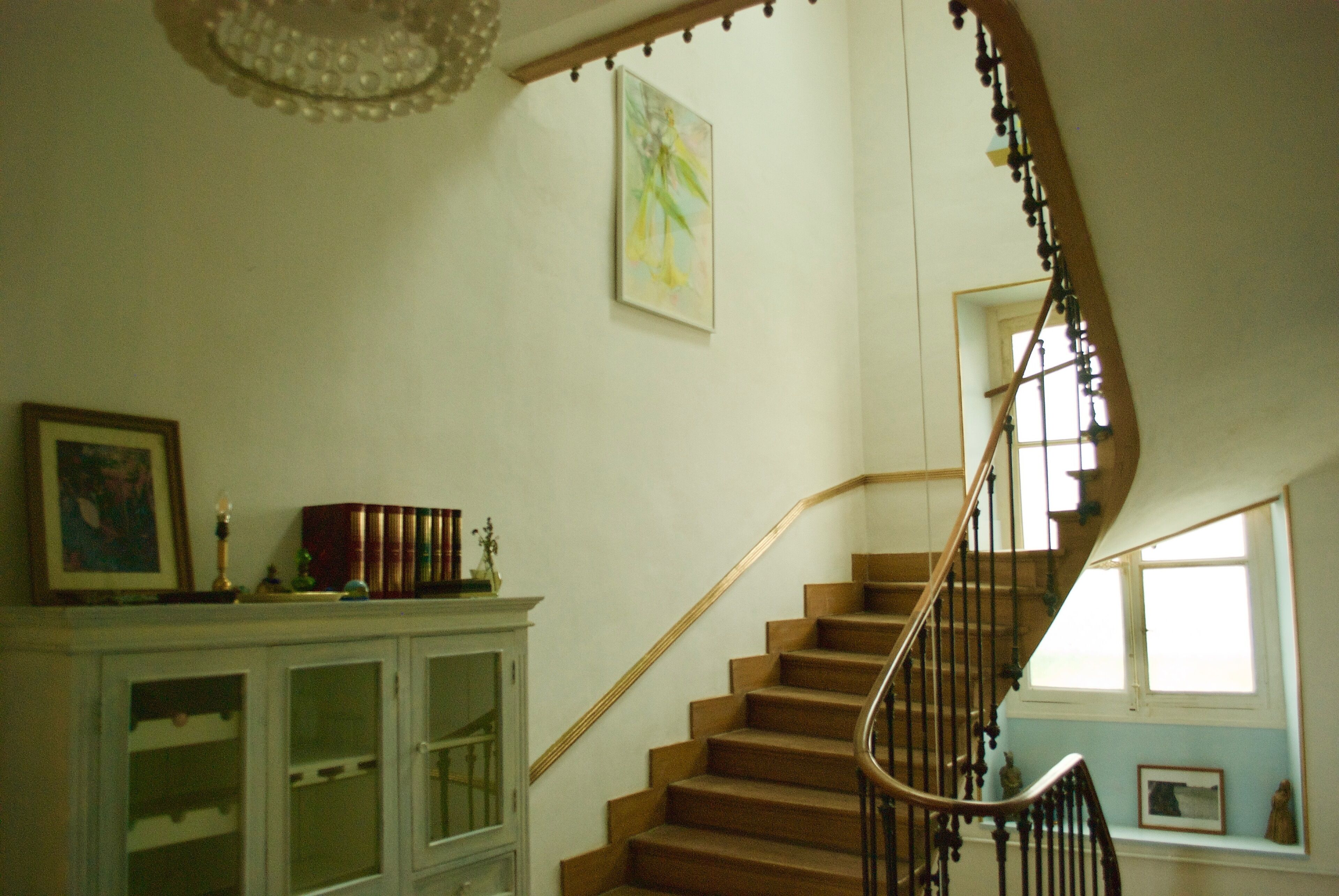 A staircase with wooden steps and a metal railing, leading to an upper floor.