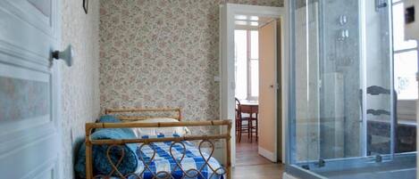 A room with a bed, a door, and a window.