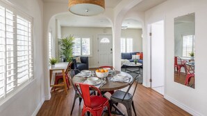 A dining area with a round table, red and black chairs, and a hanging light fixture. - 3blocks2beach, Free Parking, A/C, Fast Wifi (San Diego)