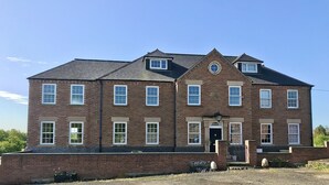 A large brick building with multiple windows and a central entrance. - Marehay Hall Farm (Ripley)