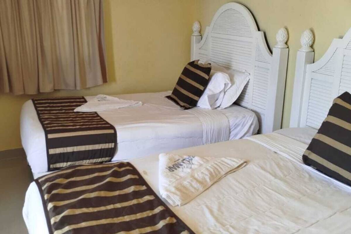 Una habitación con dos camas individuales, cada una con ropa de cama y almohadas a rayas.