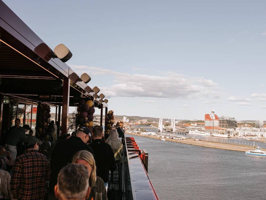 En restaurang vid vattnet med utsikt över hamnen och en bro.