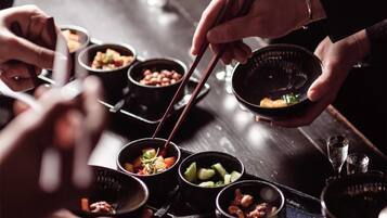 A person serving food from small bowls on a tray.