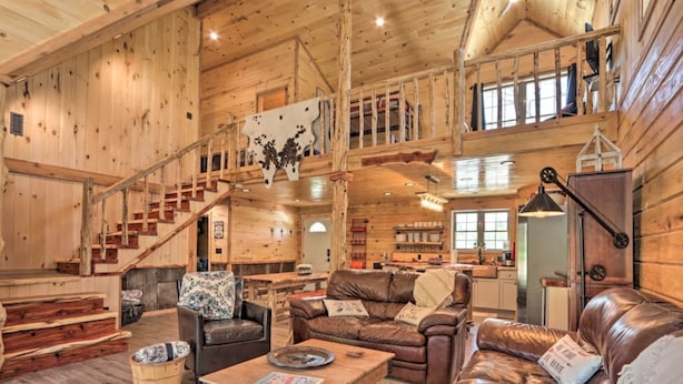 A spacious log cabin interior with a living room, kitchen, and a loft bedroom area. - Newly built LOG Cabin-Float, Golf, Hike, Hunt, Fish, visit a winery...Relax! (cuba)