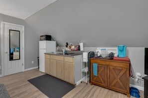 A compact kitchen with a microwave, sink, and wooden cabinets.