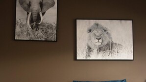 A bedroom with a bed, a nightstand with a lamp, and two framed wildlife photographs on the wall. - Cosy 2-bedroom Apartment in the Center of Hotton (Hotton)