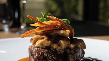 A steak dish with mushrooms and caramelized onions on a white plate.