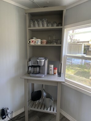 Kitchenette with sink, coffee maker, and storage for essentials.