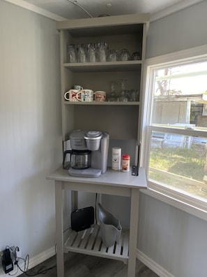 Kitchenette with sink, coffee maker, and storage for essentials.