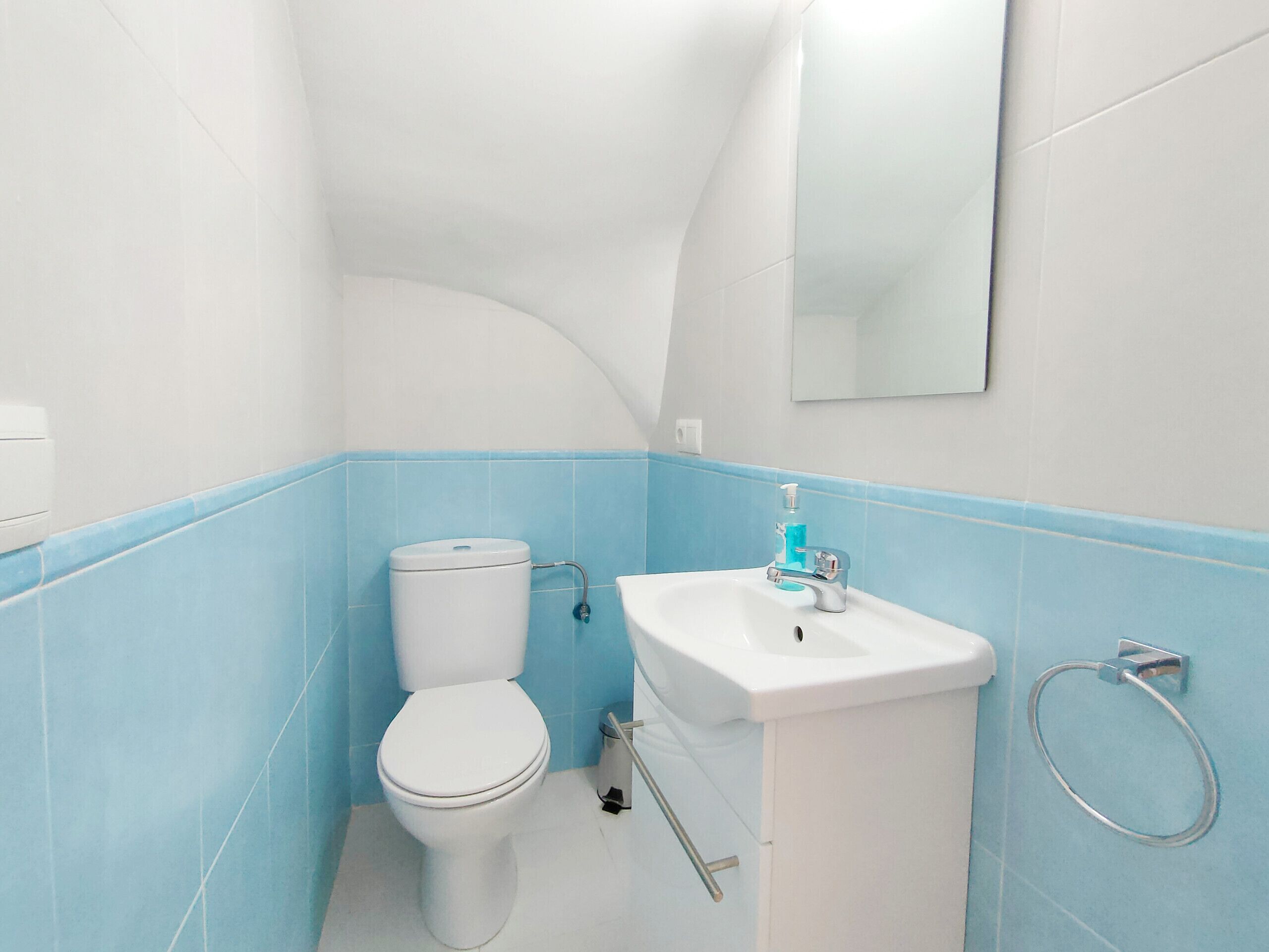 Ein Badezimmer mit Toilette, Waschbecken und Handtuchhalter.