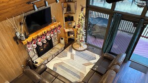 Een gezellige woonkamer met een open haard, leren bank en een kerstboom.