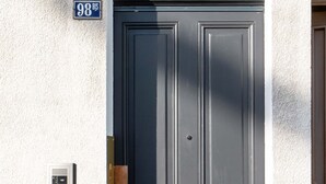 A black double door with a keypad lock, a mailbox, and a house number sign. - Studio B, in the city center, cozy and warm... (La Roche-sur-Yon)