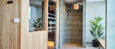 A modern hallway with wooden paneling, a glass door leading to a room, and a potted plant on the right.