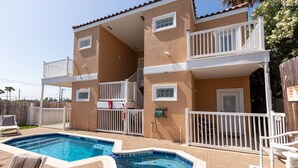 Un bâtiment à deux étages doté d’une piscine, de balustrades blanches et d’une terrasse clôturée.