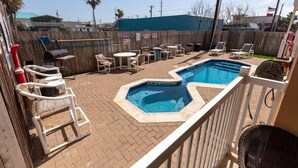 Un jardin avec une piscine, des chaises longues et une clôture en bois.