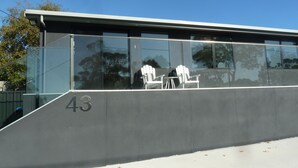 A modern building with a glass facade and the number 43. - Situated across the road from the beach (Bridport)