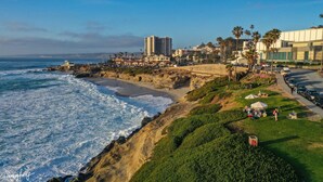Un paisaje urbano costero con playa, edificios y palmeras.