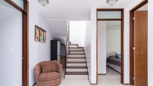Ein Flur mit einer Treppe, die zu einem Schlafzimmer führt.
