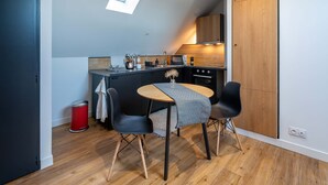 A compact kitchen with a dining area, a skylight, and wooden flooring. - Studio C, in the center of town, cosy and warm. (La Roche-sur-Yon)