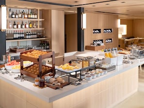 Un buffet proposant une variété de plats, un choix de vins et un espace réservé aux convives.