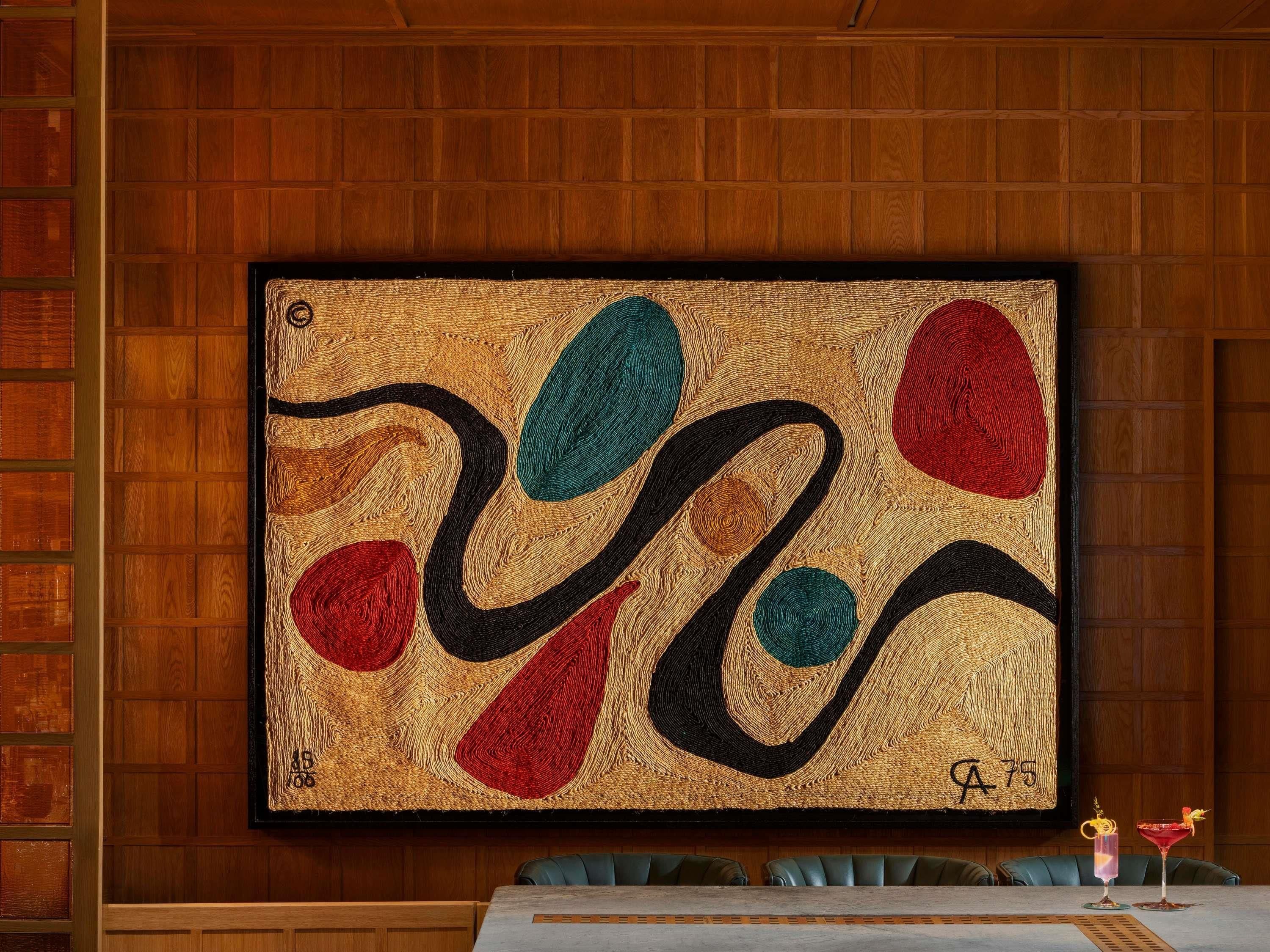 A framed abstract painting on a wooden wall.