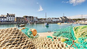 A harbor with boats and fishing nets, buildings along the waterfront, and a clear sky. - Vannes, 4-star luxury flat with car park (Vannes)
