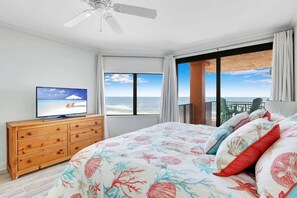A bedroom with a bed, a television, a dresser, and a balcony with a view of the ocean. - Four Seasons 402-E, Private fishing pier (Orange Beach)