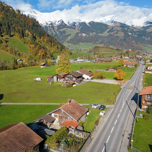 A rural village with houses, a road, and mountains in the background.