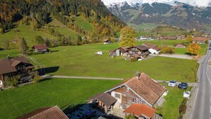 A rural village with traditional houses, a road, and a mountain backdrop.