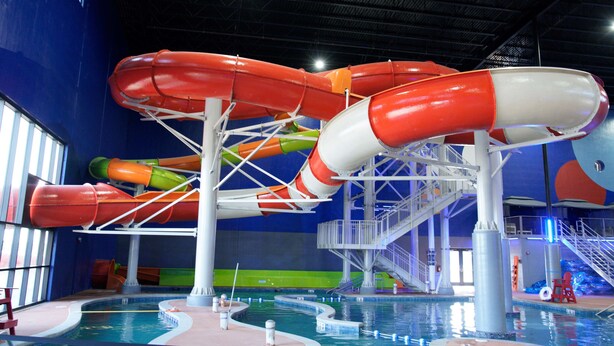 Un parc aquatique intérieur doté de nombreux toboggans et de plusieurs piscines.