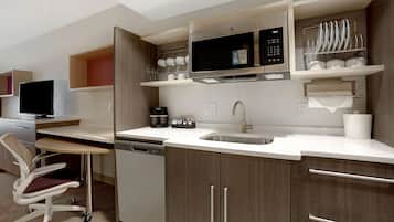 A modern kitchen with a dishwasher, microwave, and a coffee maker.