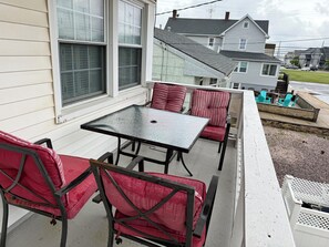 A balcony with a table and chairs, overlooking a residential area. - Elegant and Bright Ocean Block Home w/ Private Balcony, BBQ & Patio (Seaside Park)