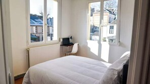 Enjoy a peaceful retreat with a large bed and desk area, offering a view of the surrounding cityscape.