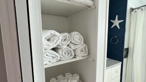 A neatly organized bathroom with a white vanity, a starfish decoration on the wall, and a shower curtain.