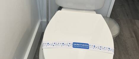Des toilettes blanches avec un autocollant indiquant : « DÉSINFECTÉES POUR VOTRE SÉCURITÉ ».