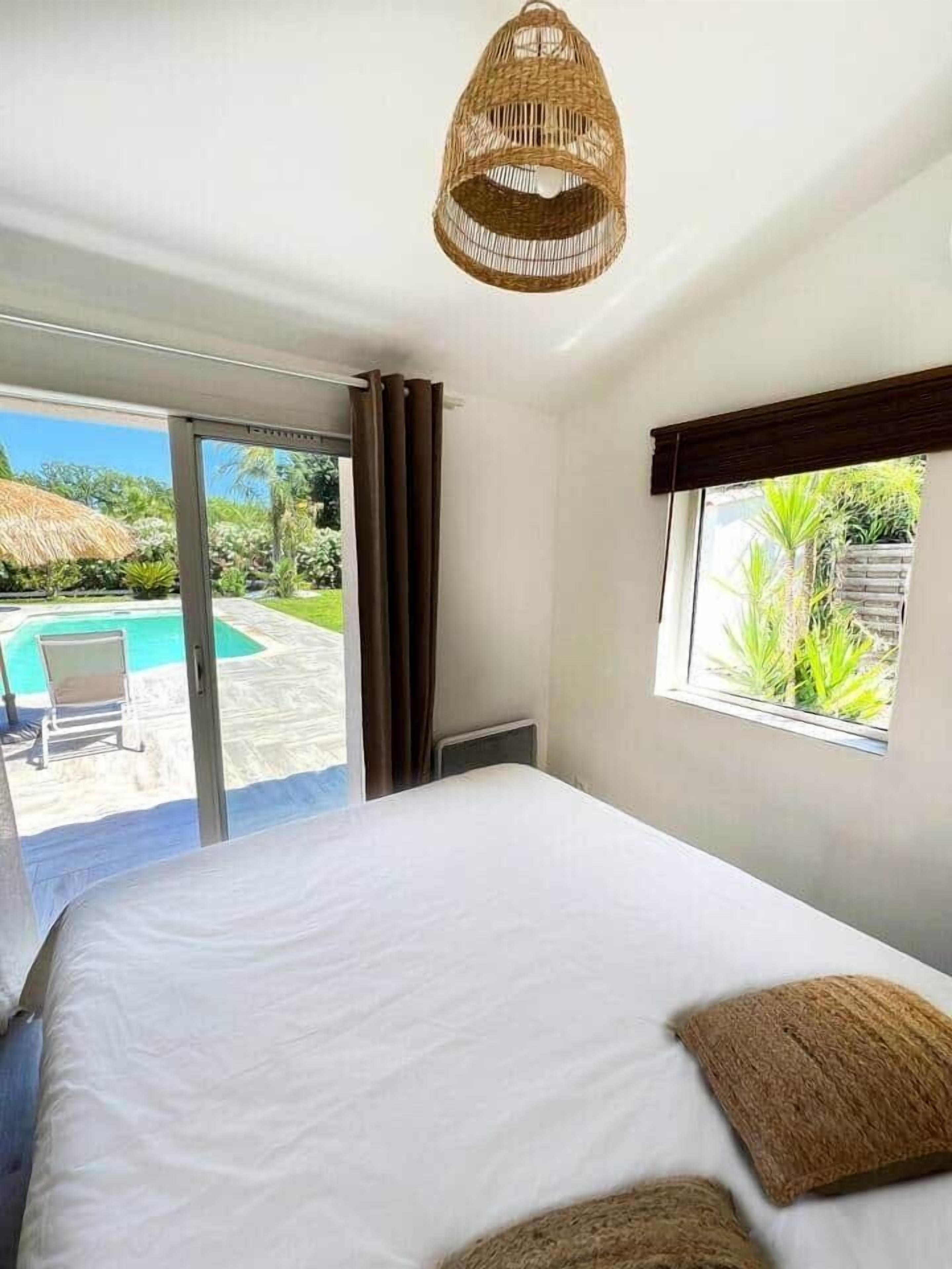 Une chambre avec un lit, une fenêtre et une vue sur une piscine et un jardin.