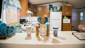 A kitchen with wooden cabinets, a white refrigerator, and various kitchen items on the counter. - Lake front retreat, covered boat dock, large deck, fenced play area, RV parking (Eufaula)
