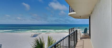 Un balcon avec vue sur la plage et l’océan.