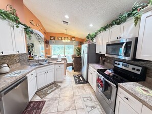 A kitchen with white cabinets, a microwave, an oven, and a dishwasher.